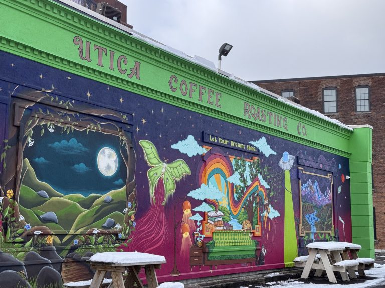 A mural painted on the exterior brick wall of Utica Coffee Roaster's Downtown utica location in winter